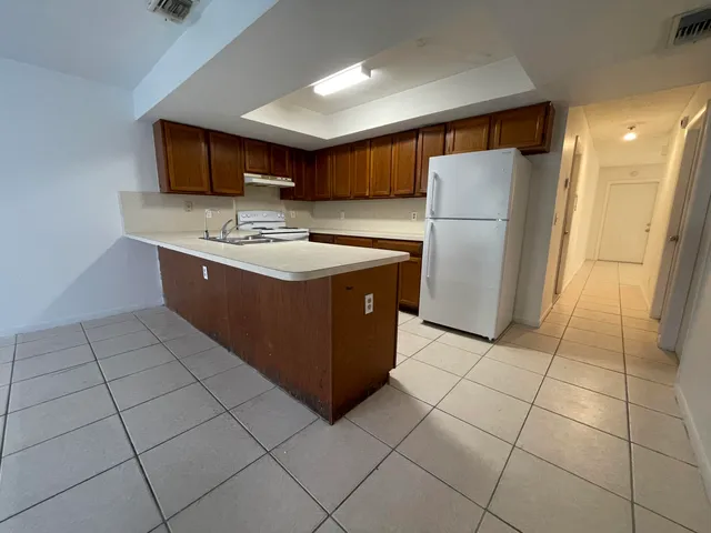a kitchen with stainless steel appliances granite countertop a stove a refrigerator and a cabinets