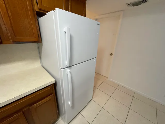 a white refrigerator freezer and a stove sitting inside of a kitchen