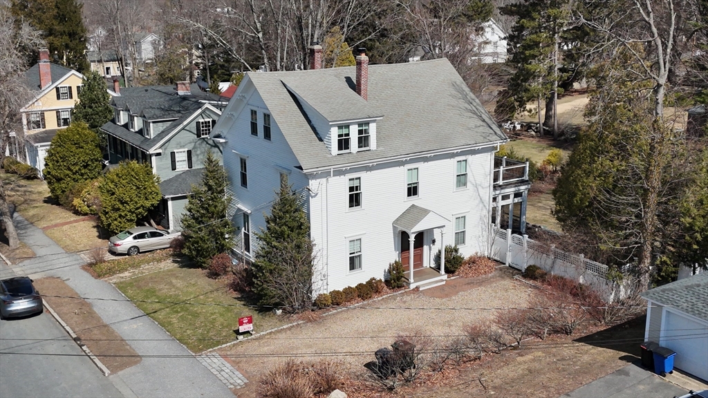 154 Main Street Andover, MA 01810 - Photo 2 of 42 a view of a white house next to a road and covered with trees