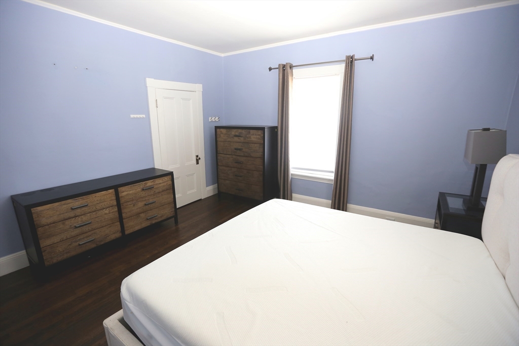 154 Main Street Andover, MA 01810 - Photo 29 of 42 a bedroom with a bed and wooden floor