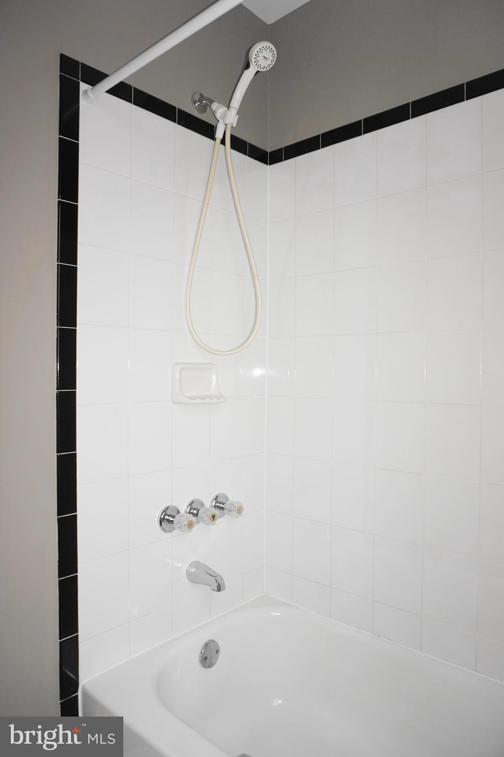 7459 School Avenue Dundalk, MD 21222 - Photo 13 of 23 a bathroom with a shower and a glass door