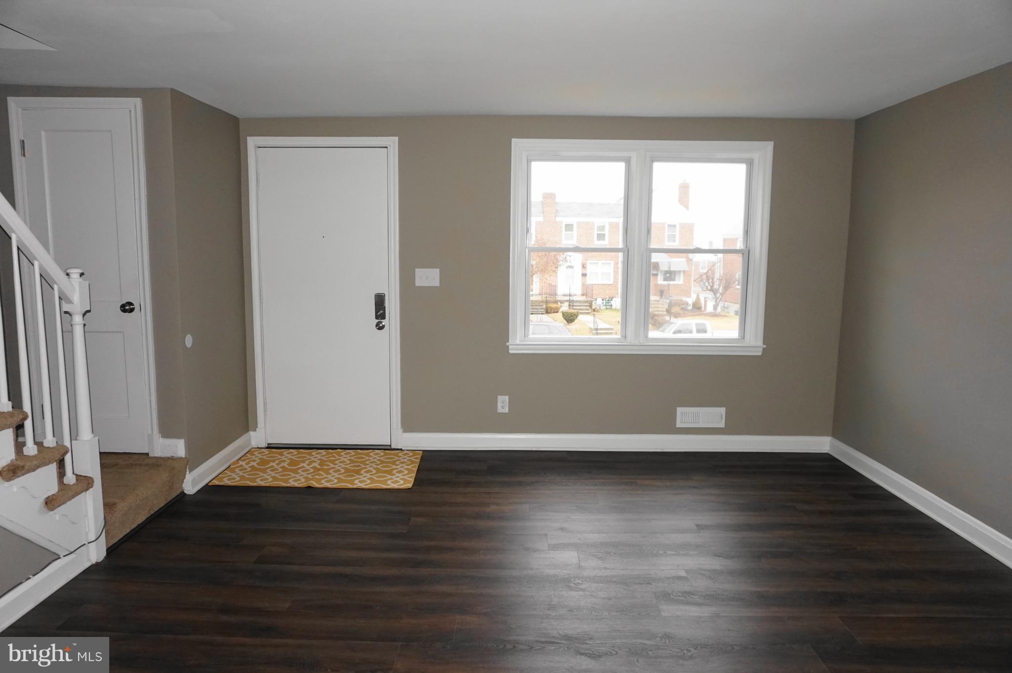 7459 School Avenue Dundalk, MD 21222 - Photo 2 of 23 an empty room with wooden floor and windows