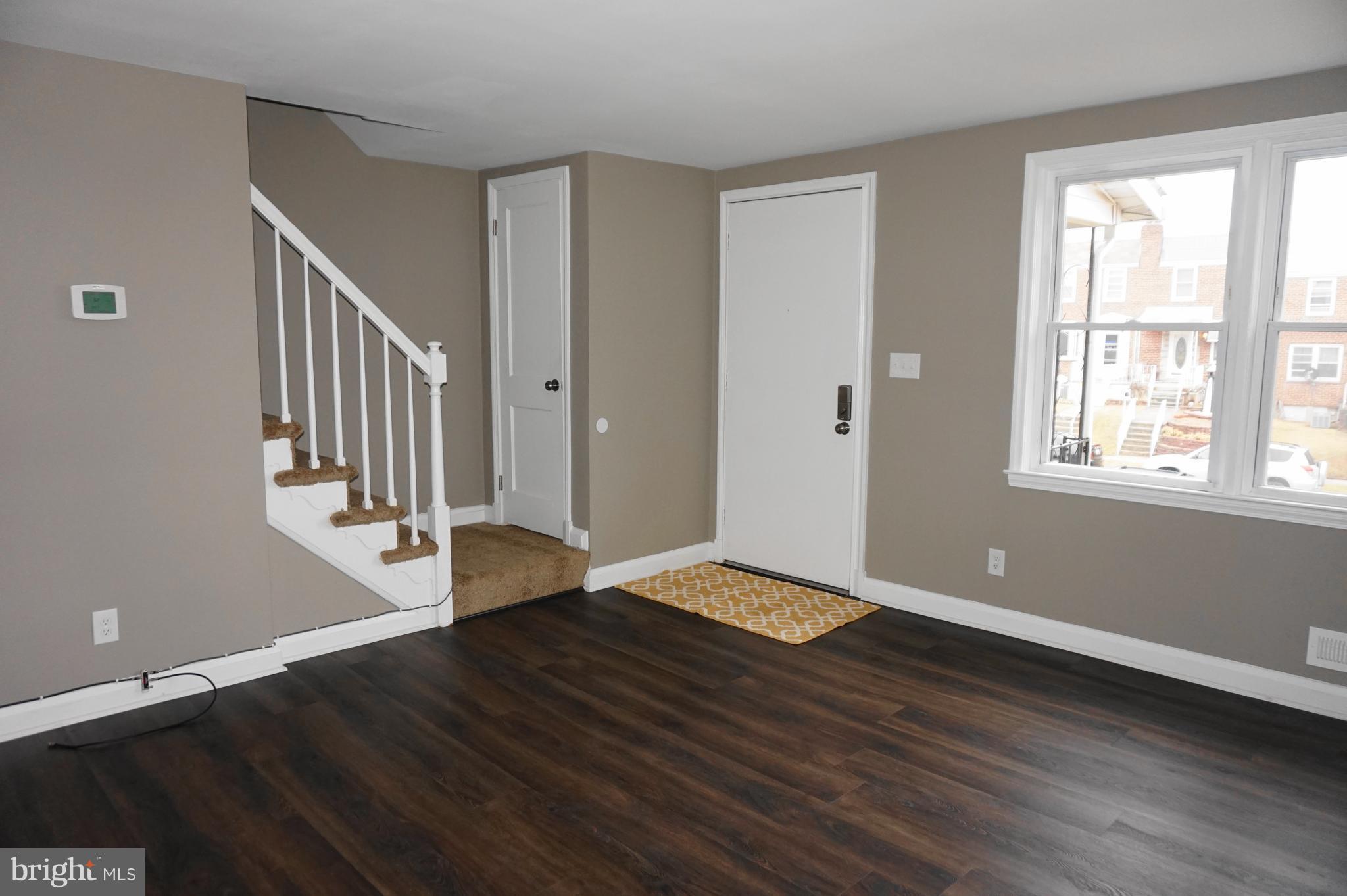 7459 School Avenue Dundalk, MD 21222 - Photo 3 of 23 a view of an empty room with wooden floor and a window