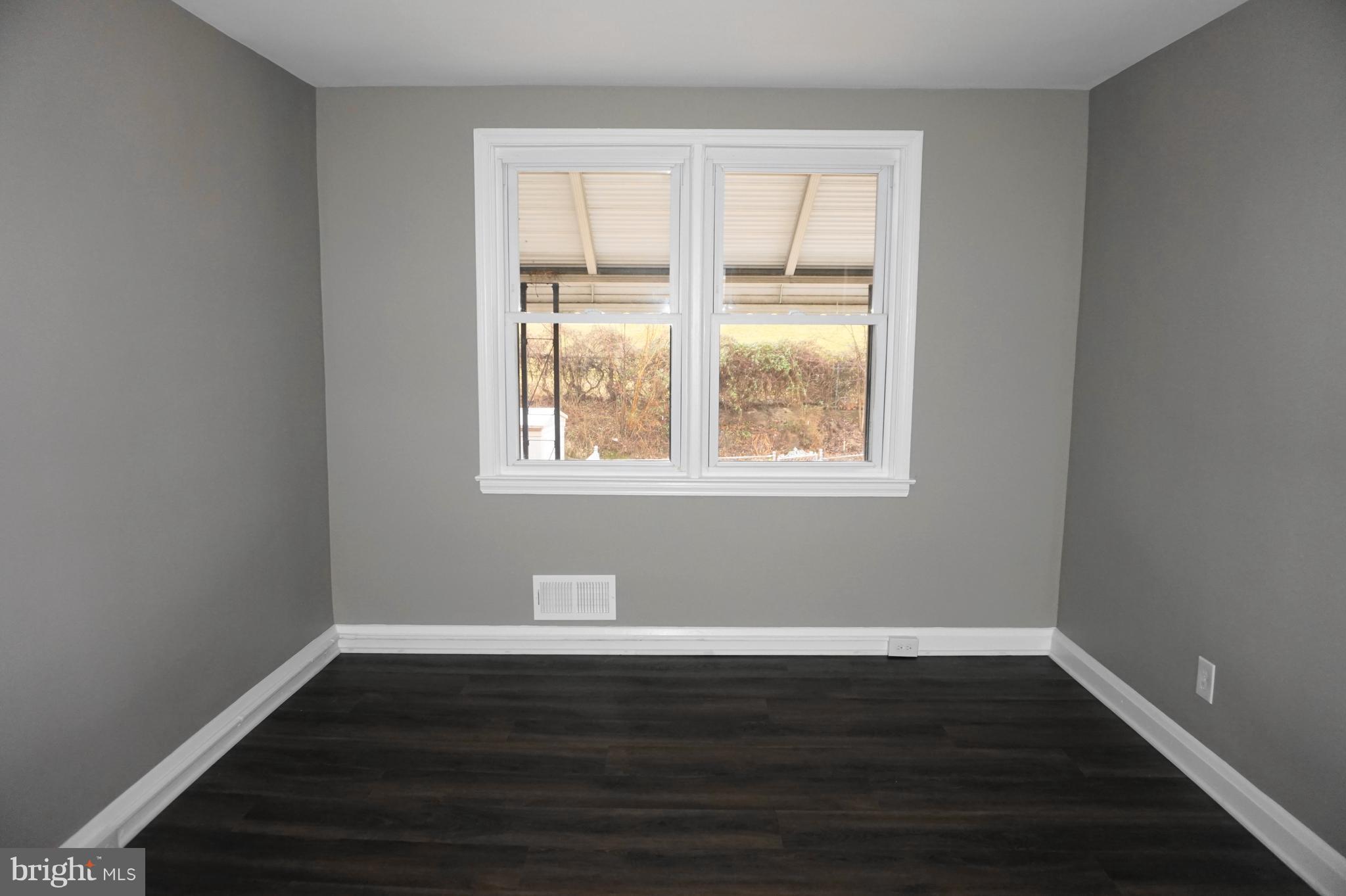 7459 School Avenue Dundalk, MD 21222 - Photo 5 of 23 a view of an empty room with wooden floor and a window