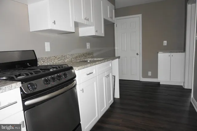 a kitchen with wooden floor and a stove top oven