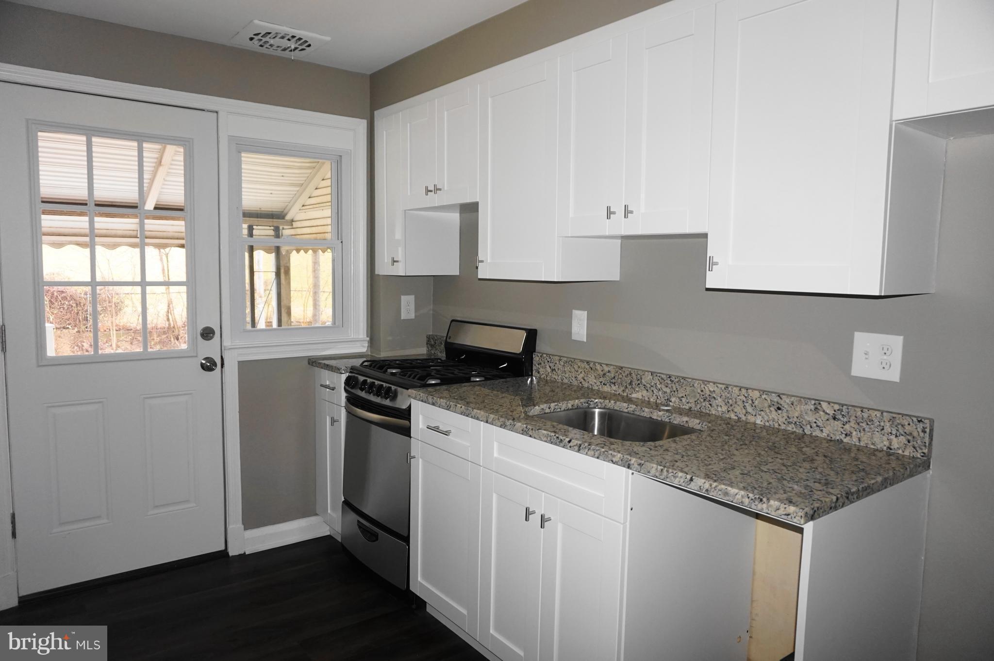 7459 School Avenue Dundalk, MD 21222 - Photo 9 of 23 a kitchen with granite countertop a sink and a stove