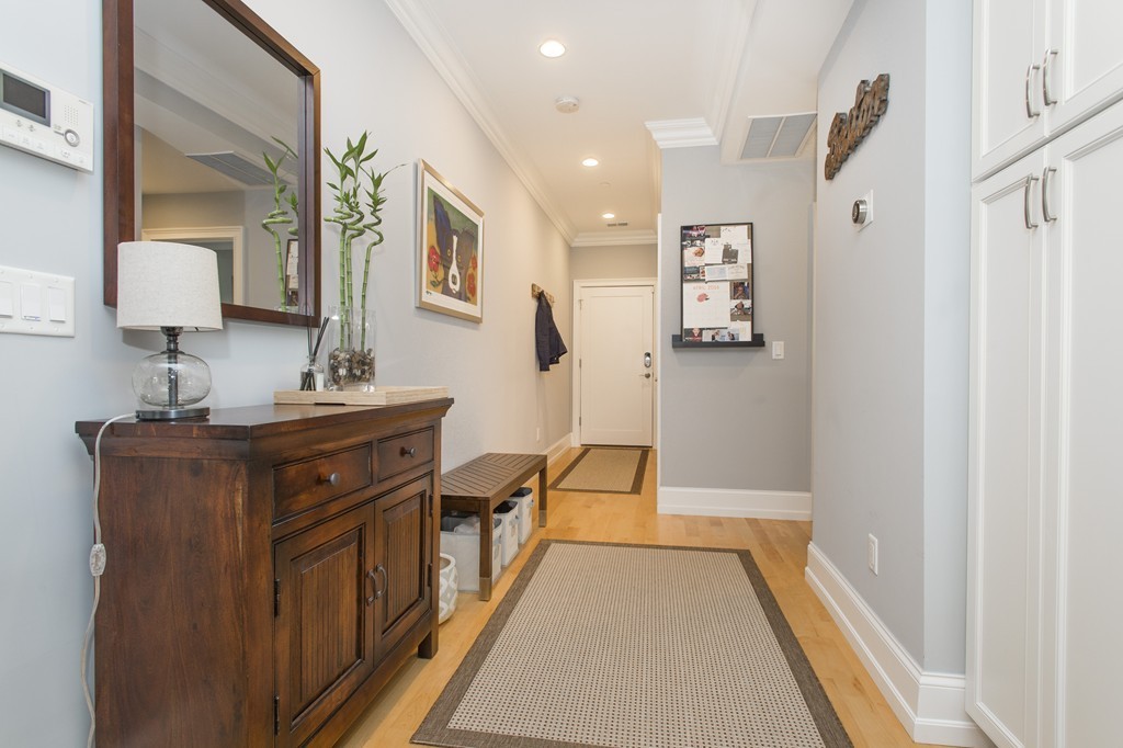 37 P Street, Unit 4 Boston, MA 02127 - Photo 4 of 13 a hallway view with furniture a mirror and wooden floor