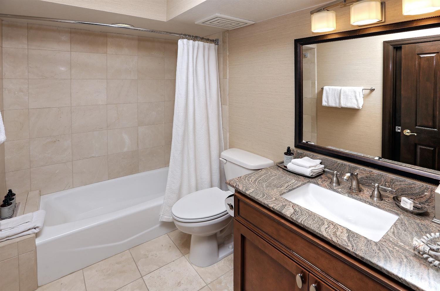 210 Offerson Road, Unit 115 WEEK 38 Beaver Creek, CO 81620 - Photo 11 of 37 a bathroom with a granite countertop bathtub sink vanity mirror and toilet