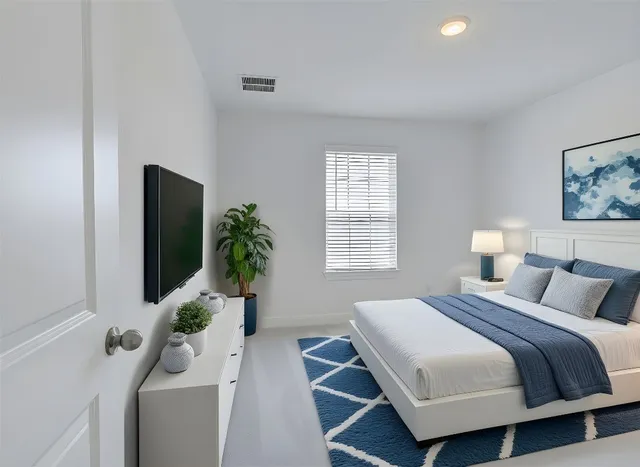 a bedroom with a bed and a potted plant