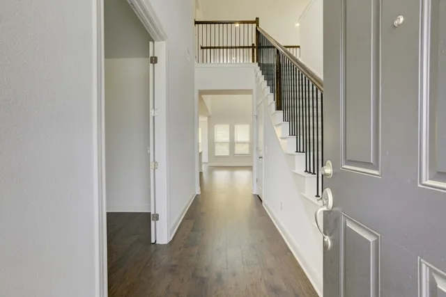 a view of a hallway with wooden floor and staircase