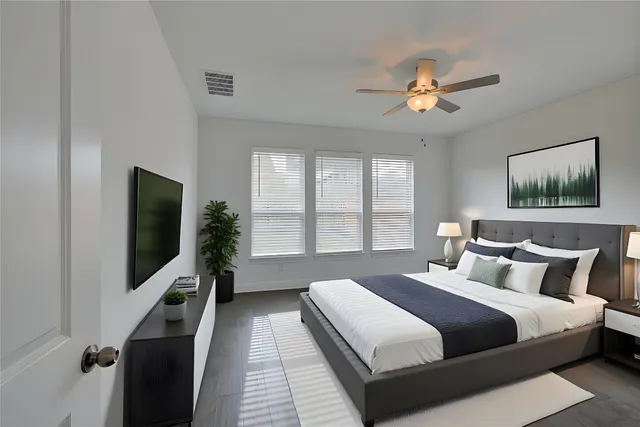 a bedroom with a large bed and a flat tv screen on a dresser