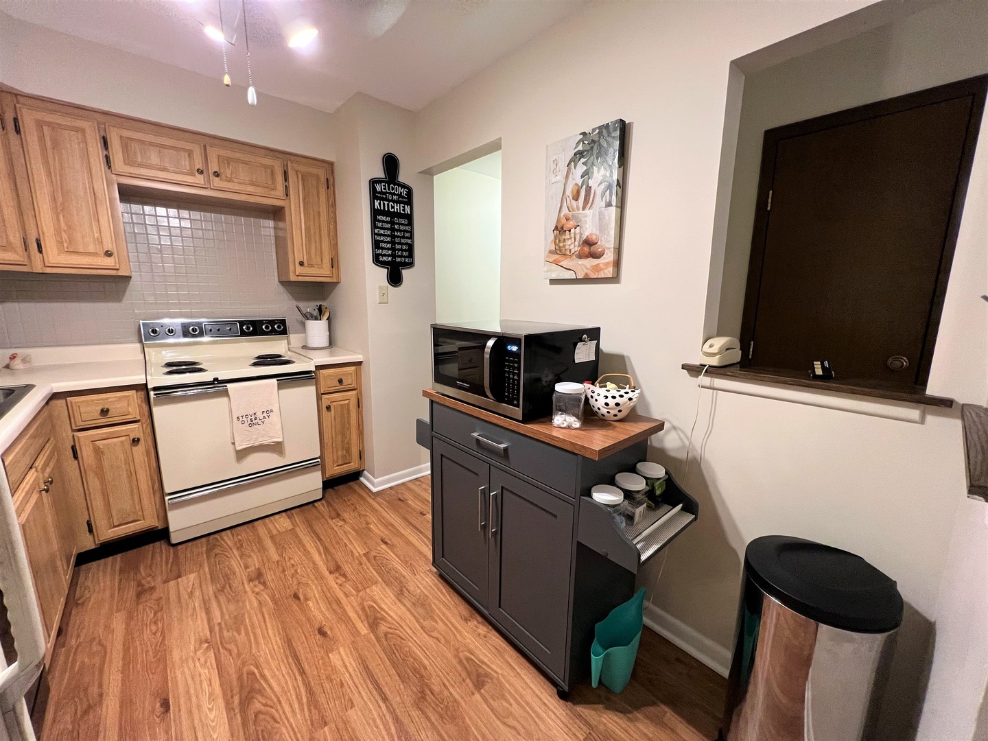 2311 183rd Street, Unit 206B Homewood, IL 60430 - Photo 6 of 26 a kitchen with stainless steel appliances granite countertop a stove top oven a sink dishwasher and white cabinets with wooden floor