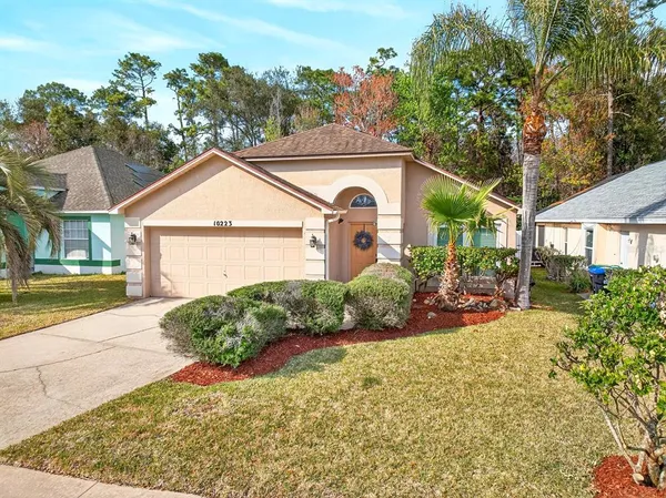 a front view of a house with a yard and potted plants