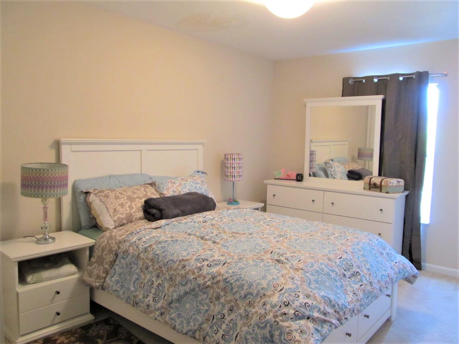 2795 Reston Street, Unit 104 Melbourne, FL 32935 - Photo 21 of 36 a bedroom with a bed and a mirror