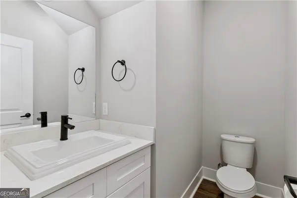 a bathroom with a sink a toilet and mirror