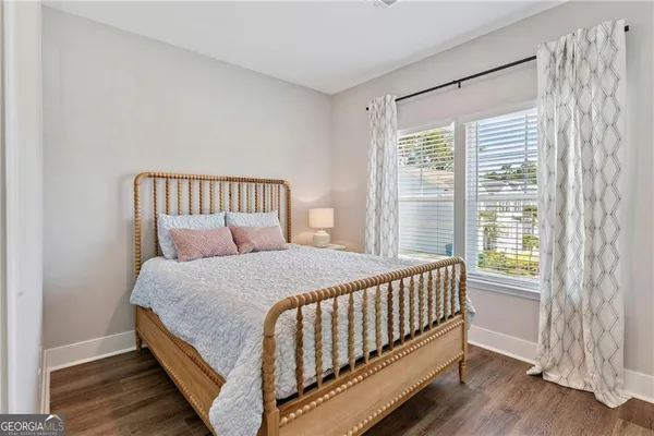 a bedroom with a bed and a window with wooden floor