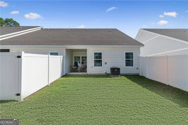 a backyard of a house with table and chairs