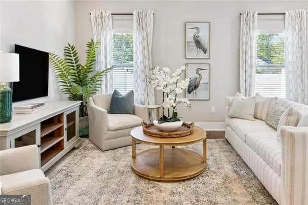 a living room with furniture a flat screen tv and a large window