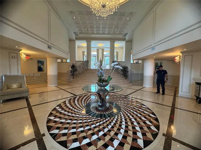 a lobby with furniture and a chandelier
