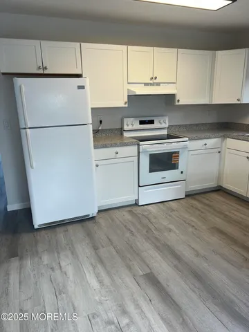 a kitchen with a refrigerator and a stove top oven