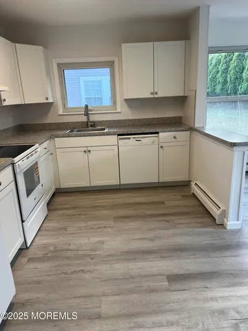 a kitchen with granite countertop a stove sink and cabinets