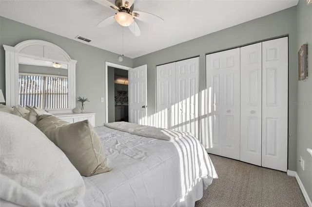 a bed sitting in a spacious bedroom next to a window