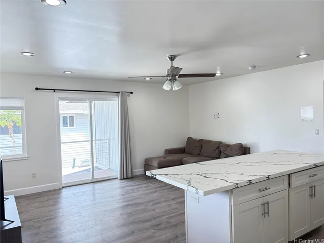 a kitchen with a stove and wooden floor