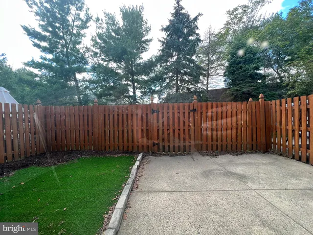 a view of backyard with wooden fence