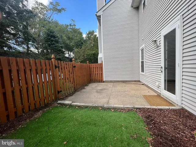 a view of backyard with wooden fence
