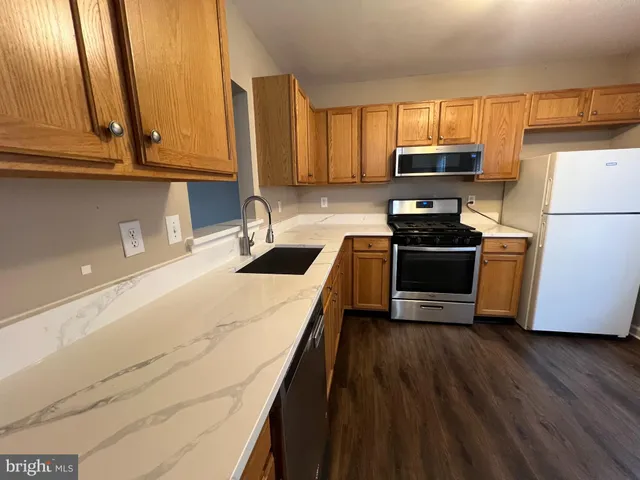 a kitchen with stainless steel appliances a stove a sink a microwave and cabinets