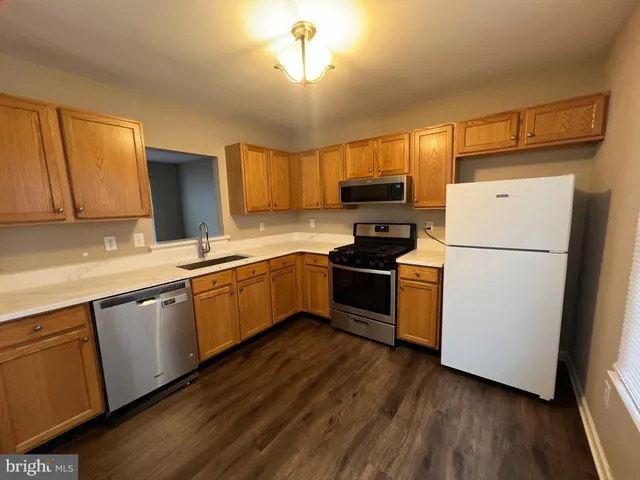 a kitchen with a sink a refrigerator a microwave and cabinets