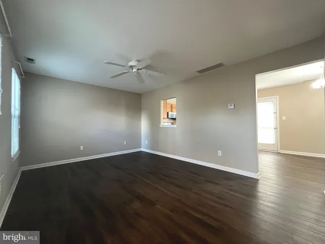 an empty room with wooden floor and window