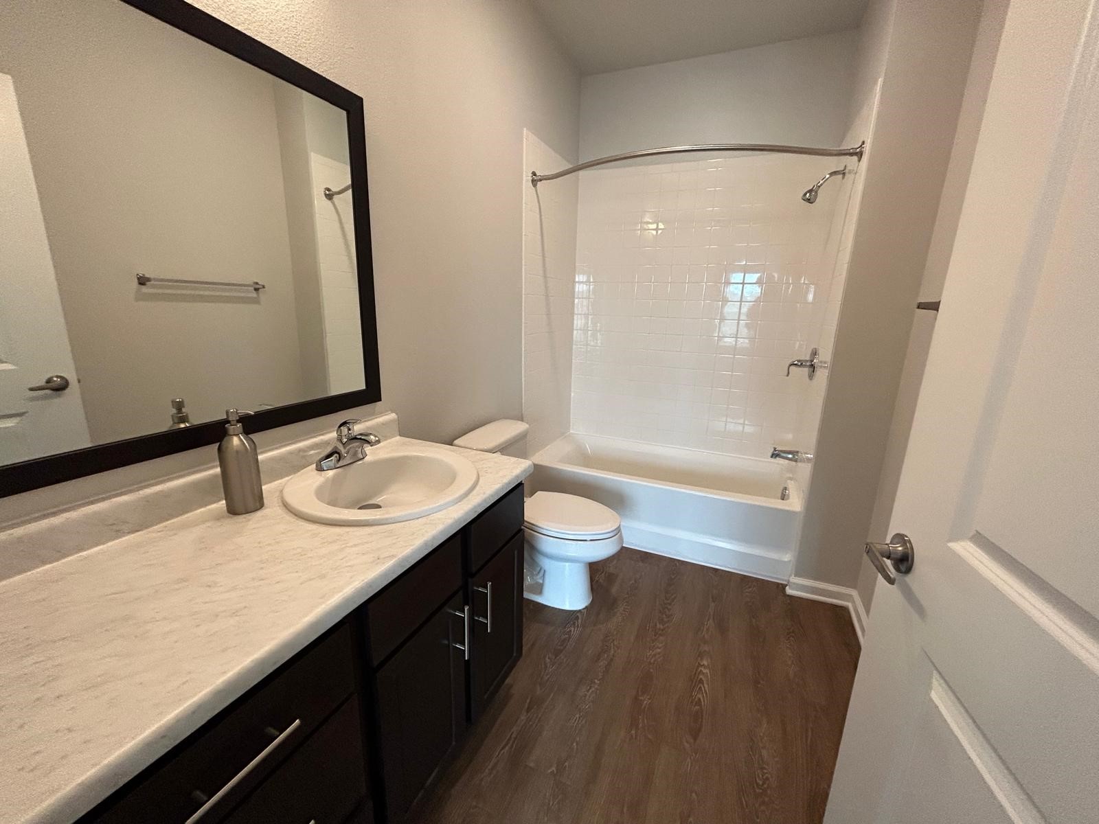 2136 West 34th Street, Unit 147 Houston, TX 77018 - Photo 4 of 11 a bathroom with a granite countertop sink a toilet a mirror and shower
