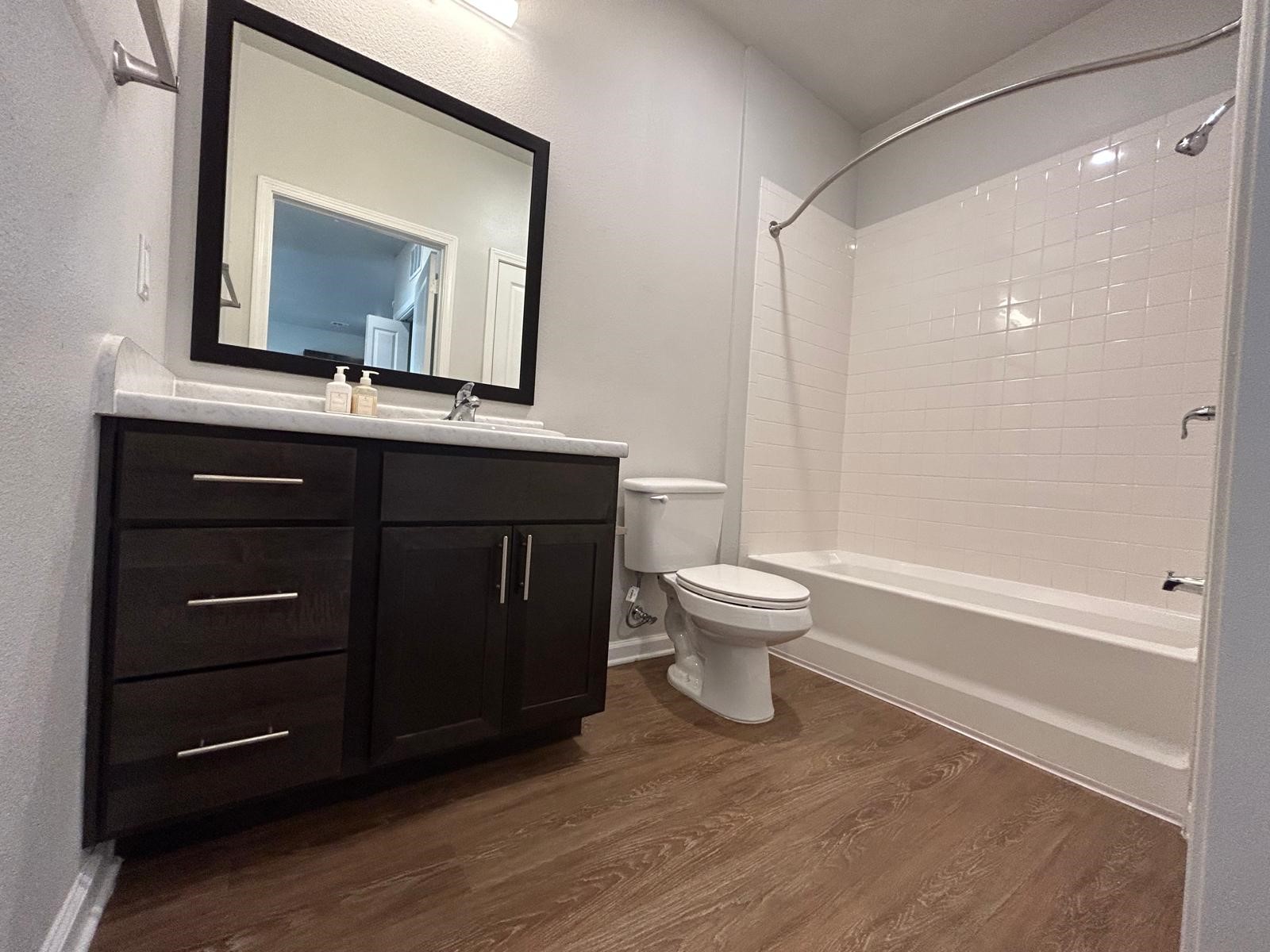 2136 West 34th Street, Unit 147 Houston, TX 77018 - Photo 8 of 11 a bathroom with a toilet a sink and mirror