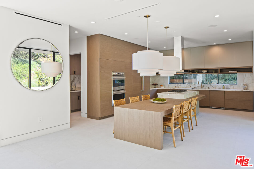 2814 Roscomare Road Los Angeles, CA 90077 - Photo 12 of 35 an open kitchen with a table and chairs
