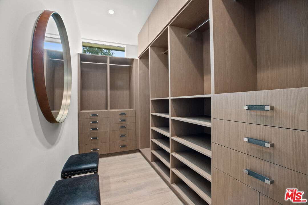 2814 Roscomare Road Los Angeles, CA 90077 - Photo 22 of 35 a view of walk in closet with clothes and shoes