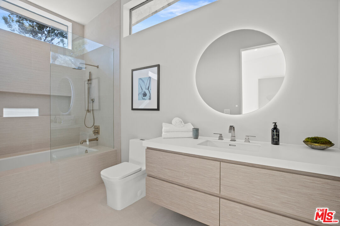 2814 Roscomare Road Los Angeles, CA 90077 - Photo 26 of 35 a bathroom with a double vanity sink toilet mirror and bathtub