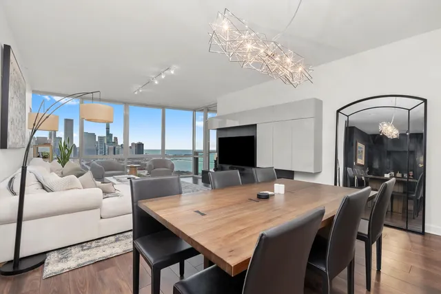a view of a dining room with furniture a chandelier and wooden floor
