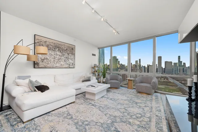a living room with furniture and a floor to ceiling window
