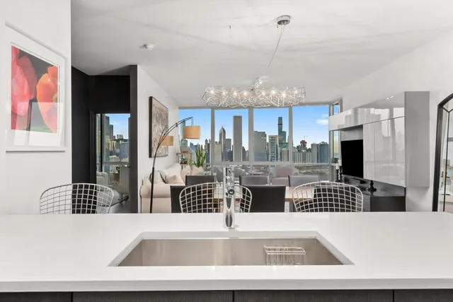 a large white kitchen with a large window and stainless steel appliances
