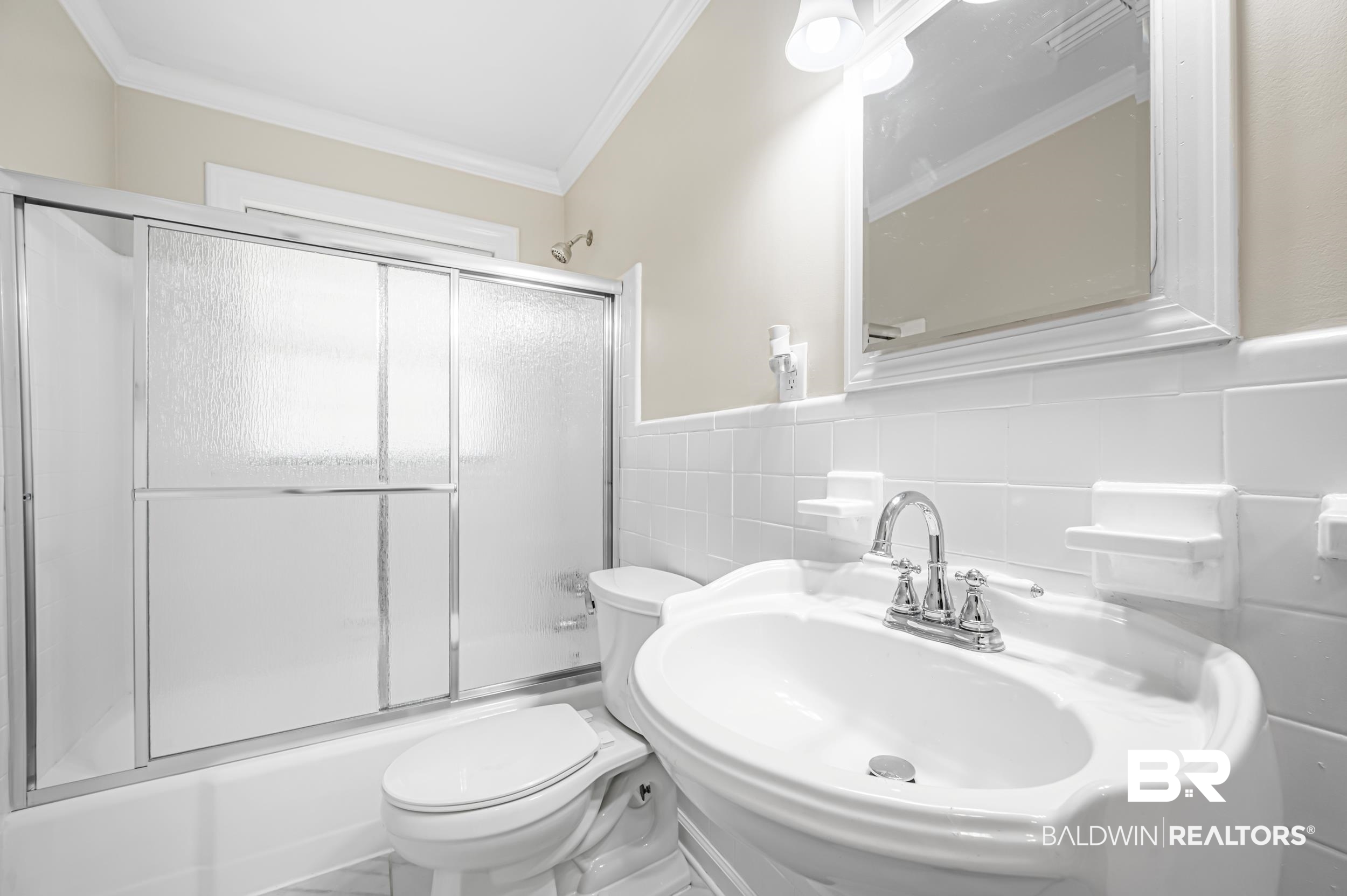 1605 Collier Avenue Bay Minette, AL 36507 - Photo 20 of 36 Full bath featuring enclosed tub / shower combo, crown molding, tile walls, and a wainscoted wall