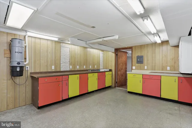 a large kitchen with stainless steel appliances kitchen island granite countertop a stove and a large window