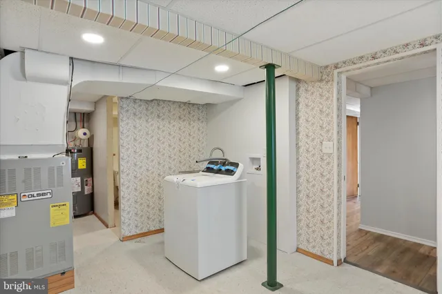 a view of storage and utility room with a fridge