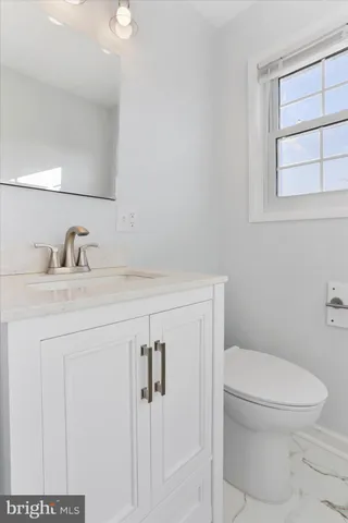 a bathroom with a toilet a sink and mirror