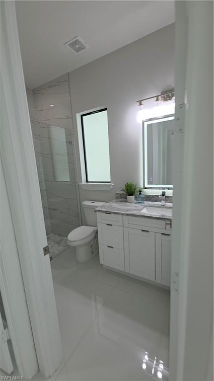 563 15th Street Northwest Naples, FL 34120 - Photo 19 of 22 a spacious bathroom with a granite countertop sink a toilet and a mirror