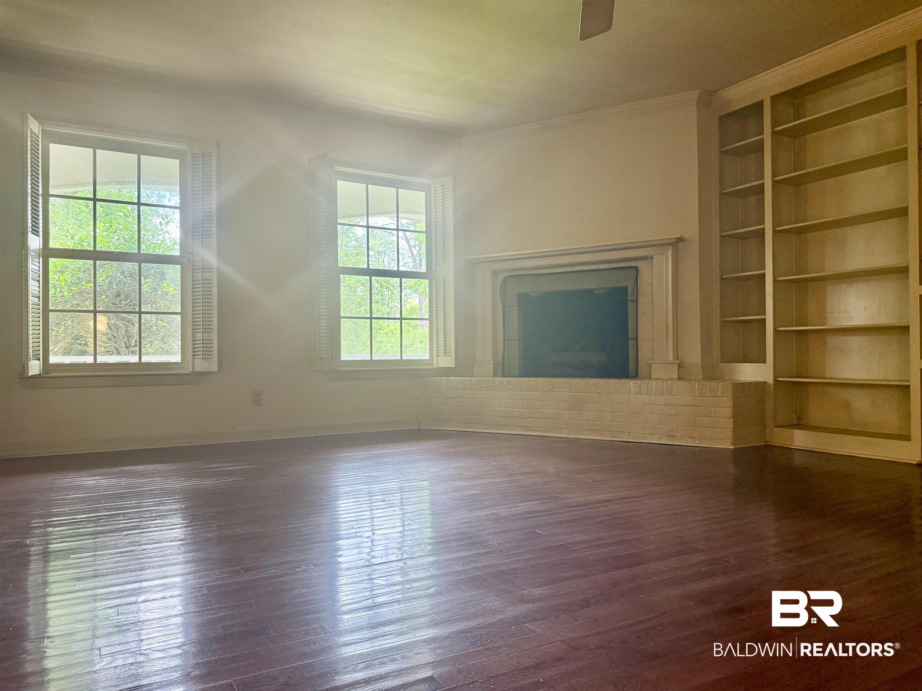 1412 Poplar Avenue Brewton, AL 36426 - Photo 15 of 32 Unfurnished living room featuring plenty of natural light, dark wood-type flooring, built in features, and crown molding