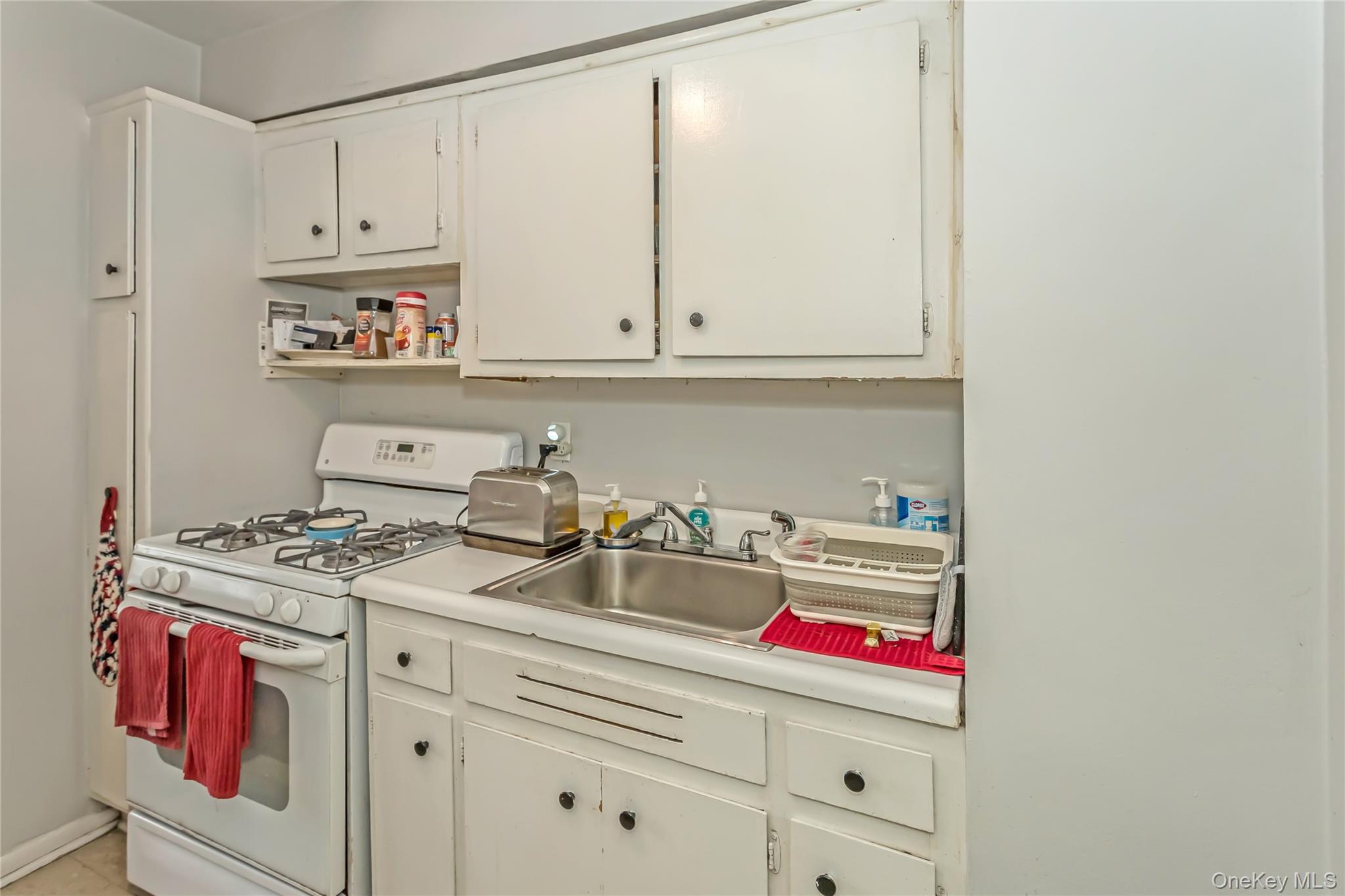 250 West Merrick Road, Unit 2L Freeport, NY 11520 - Photo 9 of 17 a kitchen with a stove and white cabinets