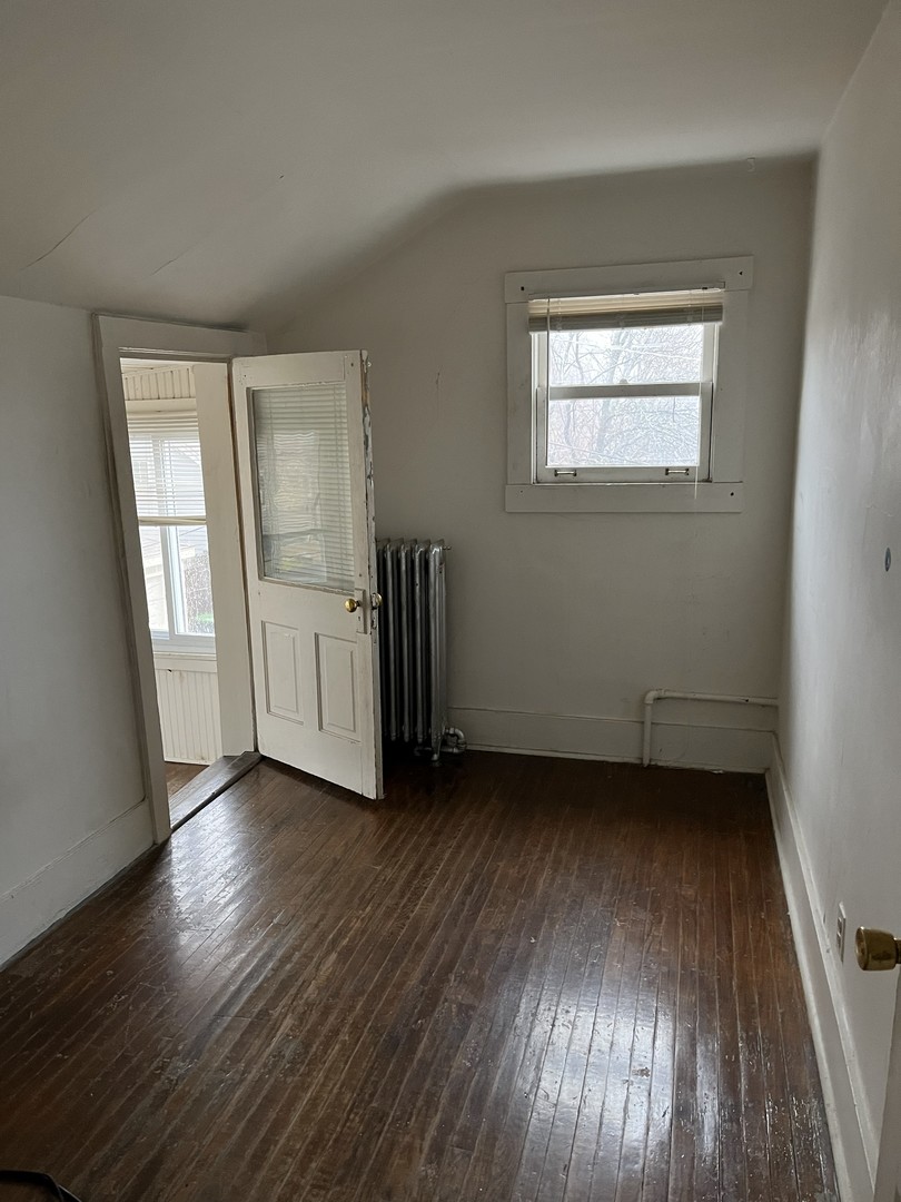 518 Hamilton Street Evanston, IL 60202 - Photo 11 of 15 an empty room with wooden floor and windows