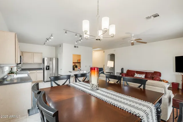 a living room with furniture kitchen view and a chandelier