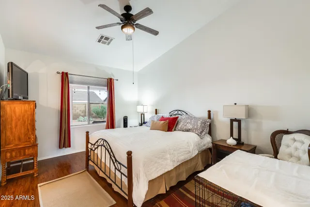 a bedroom with a bed and a flat tv screen on wall